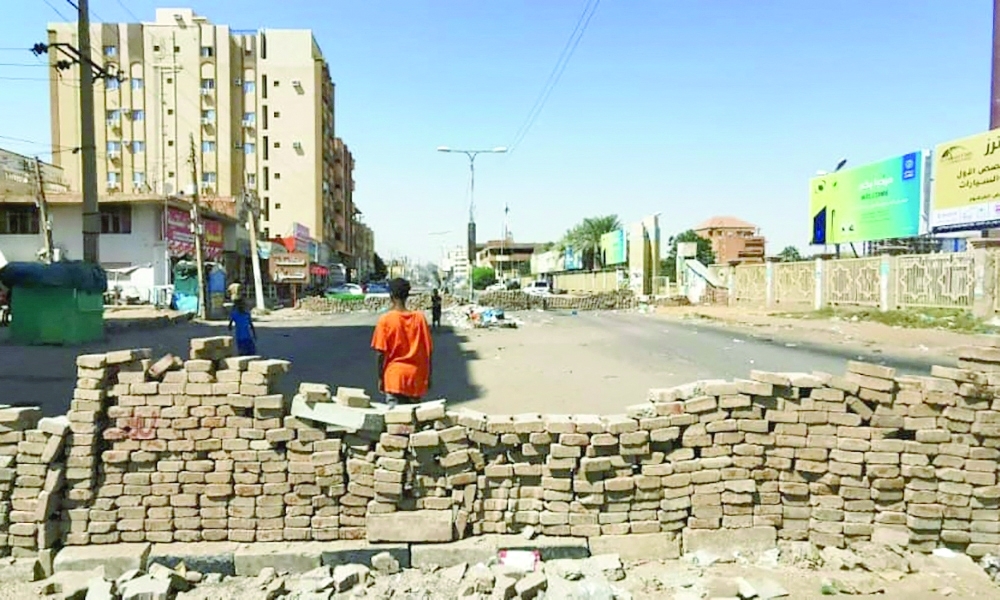 A young Sudanese man stands in front of barricades in the capital Khartoum on Sunday. - AFP