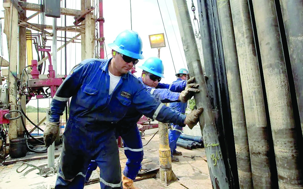 Employees work at an oil excavation pipe at Campo Rubiales field in Meta, eastern Colombia. — Reuters