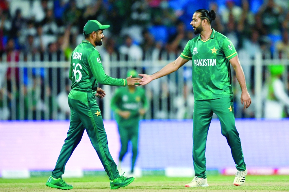 Pakistan's captain Babar Azam (L) and teammate Imad Wasim celebrate after the dismissal of Scotland's Matthew Cross. -- AFP