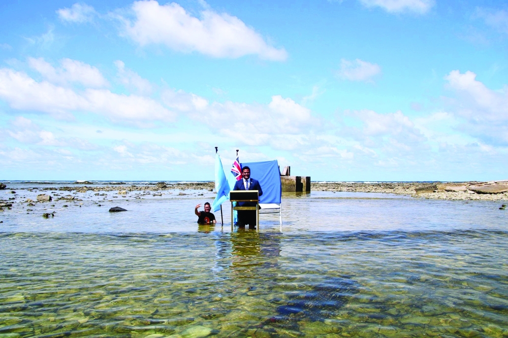 Simon Kofe gives a COP26 statement while standing in the ocean in Funafuti, Tuvalu. -- Reuters