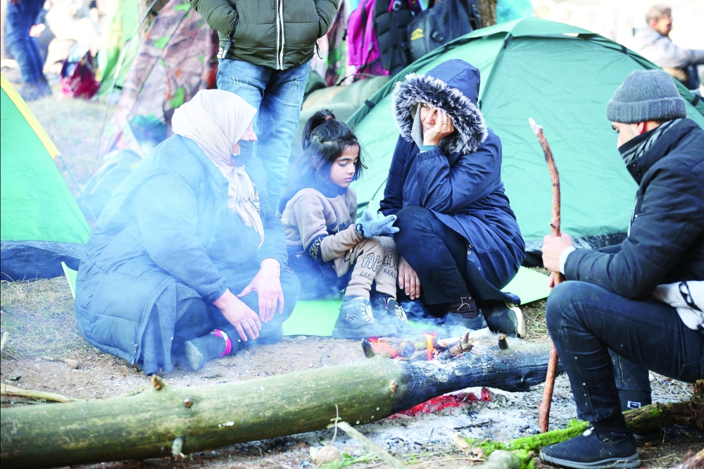 Migrants gather in a camp near the Belarusian-Polish border as they attempt to cross it in the Grodno region, Belarus on Tuesday. — Reuters