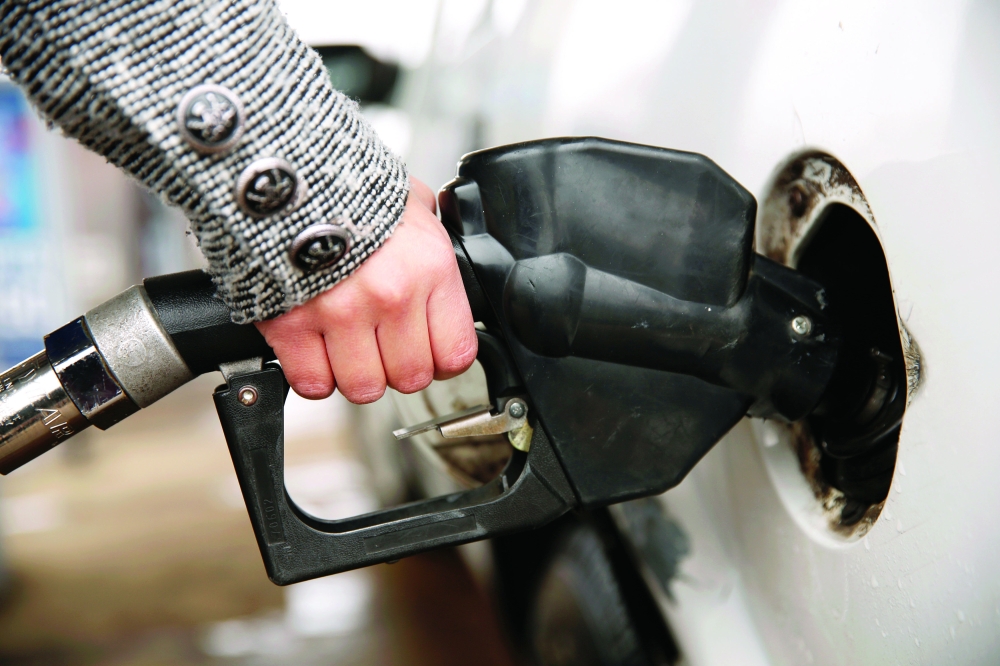 A woman pumps gas at a station in Falls Church, Virginia. — Reuters