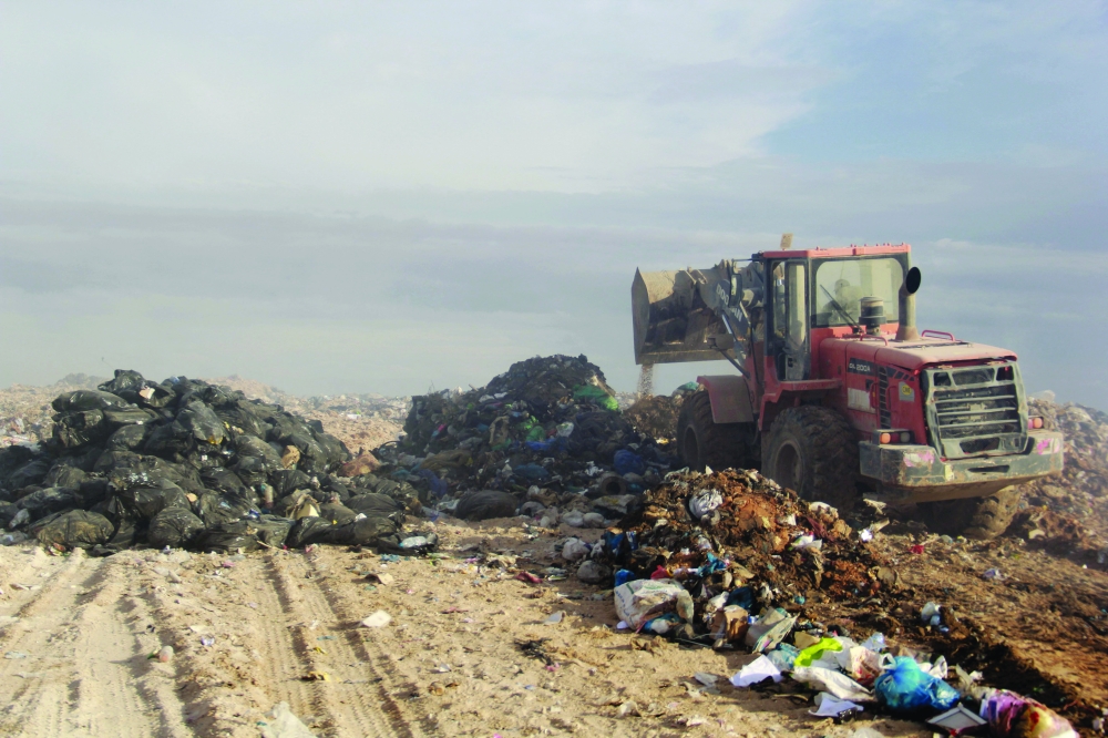 A tractor buries garbage after the reopening of a landfill in Aguereb on Tuesday. - AFP