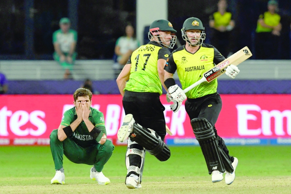 Pakistan’s Shaheen Shah Afridi (L) reacts as Australia’s Marcus Stoinis (C) and Matthew Wade run between the wickets. — AFP