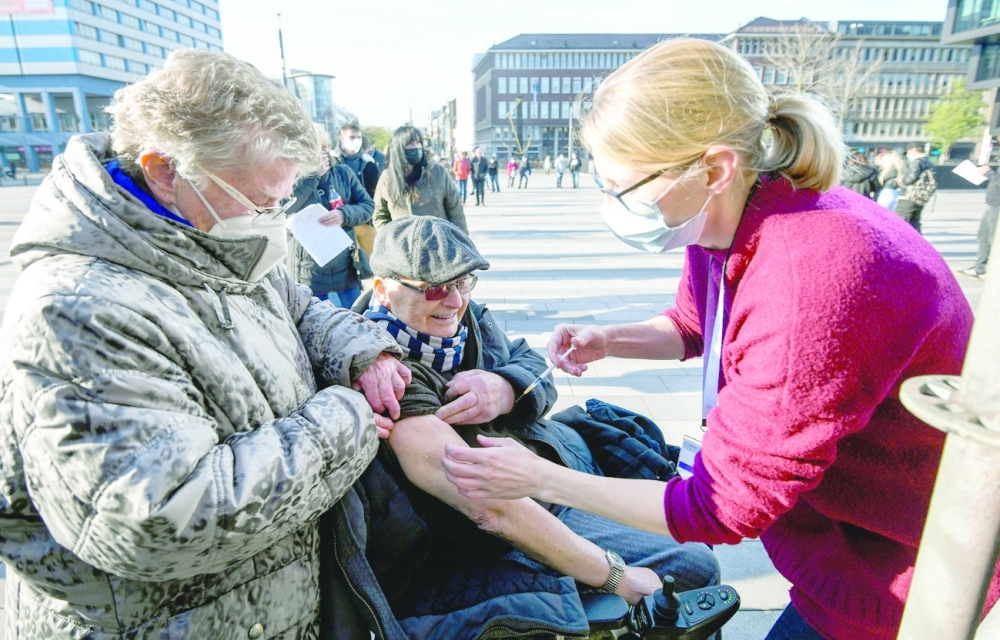 A man in a wheelchair is vaccinated outside a mobile vaccination centre set up in the city of Duisburg, western Germany, on Friday. - AFP 