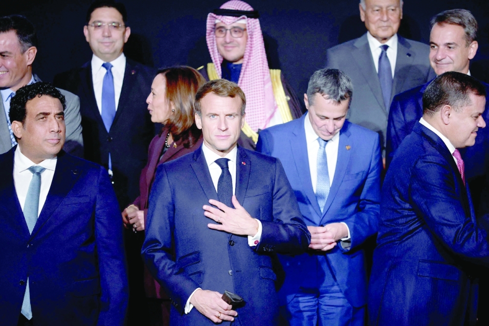 France's President Emmanuel Macron flanked by Libya's interim leaders Mohamed El-Menfi (L) and Abdul Hamid Dbeibah (R) poses for a family picture as they attend the international conference on Libya at the Maison de la Chimie in Paris on Friday. - AFP