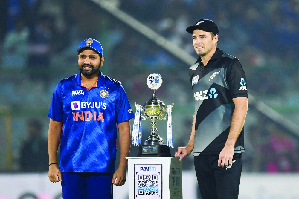 New Zealand's captain Tim Southee (R) and India's captain Rohit Sharma pose for pictures with the trophy. -- AFP