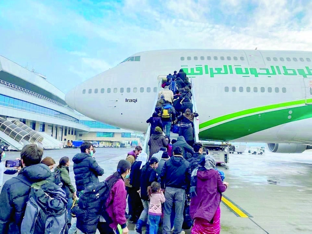 Iraqi migrants board the plane for evacuation flight at Minsk airport, Belarus on Thursday. - Reuters