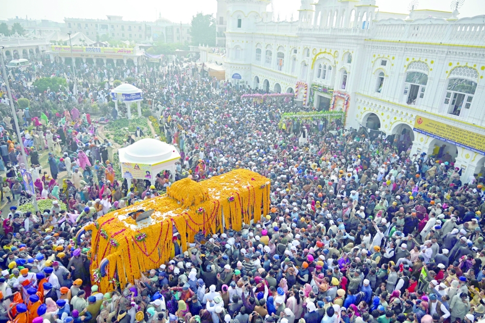 Sikh devotees gather around a bus carrying the Guru Granth Sahib (Sikh holy book) during a religious procession on the occasion of the birth anniversary of Guru Nanak Dev, the founder of Sikhism, in Nankana Sahib on Friday. - AFP