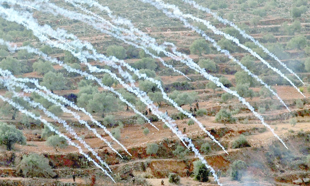 Palestinian protesters and Israeli security forces clash following a demonstration against settlements in the village of Beita in the occupied West Bank, on Friday. - AFP