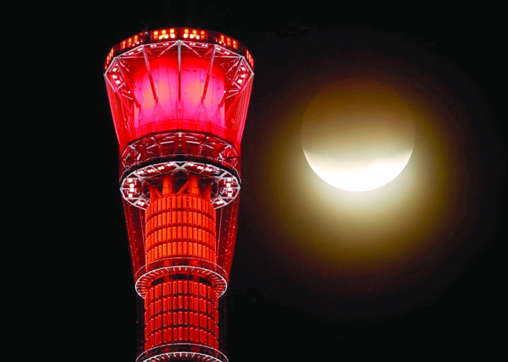 A shadow falls on the moon, as seen beside the world's tallest broadcasting tower Tokyo Skytree, during a partial lunar eclipse in Tokyo on Friday. — Reuters 