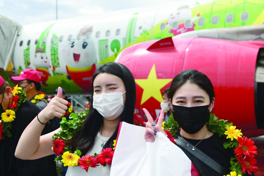South Korean tourists pose after their arrival at Phu Quoc international airport as the island welcomes its first international tourists to arrive after coronavirus vaccine passport scheme kicked off this month in Vietnam. - AFP

