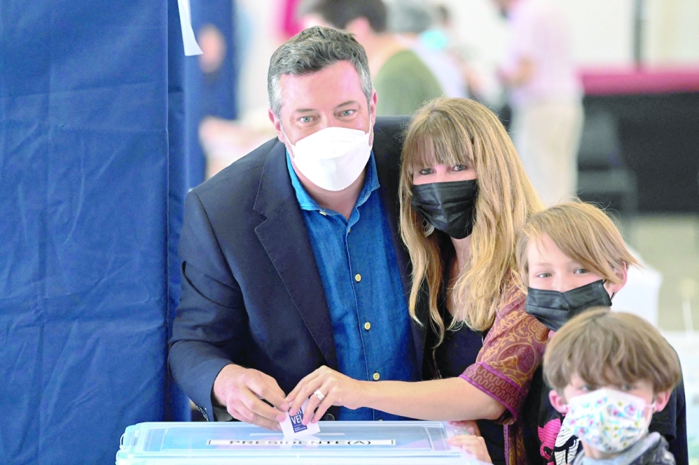 Chilean presidential candidate for the centre-right government coalition, Sebastian Sichel casts his vote with his family at a polling station in Santiago during presidential elections. - AFP