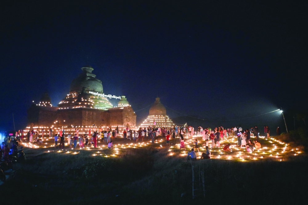 People taking part in the Tazaungdaing festival, also known as the Festival of Lights, at the pagoda in Mrauk U in Myanmar's Rakhine state. - AFP

