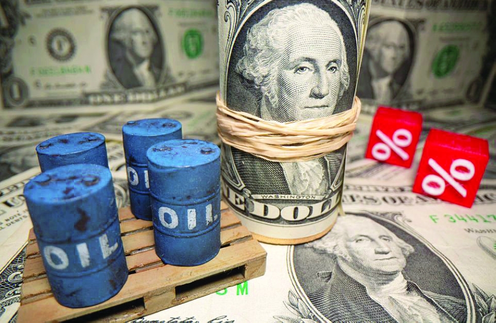 3D printed oil barrels and percentage symbols are seen in front of dollar banknotes in this illustration. — Reuters