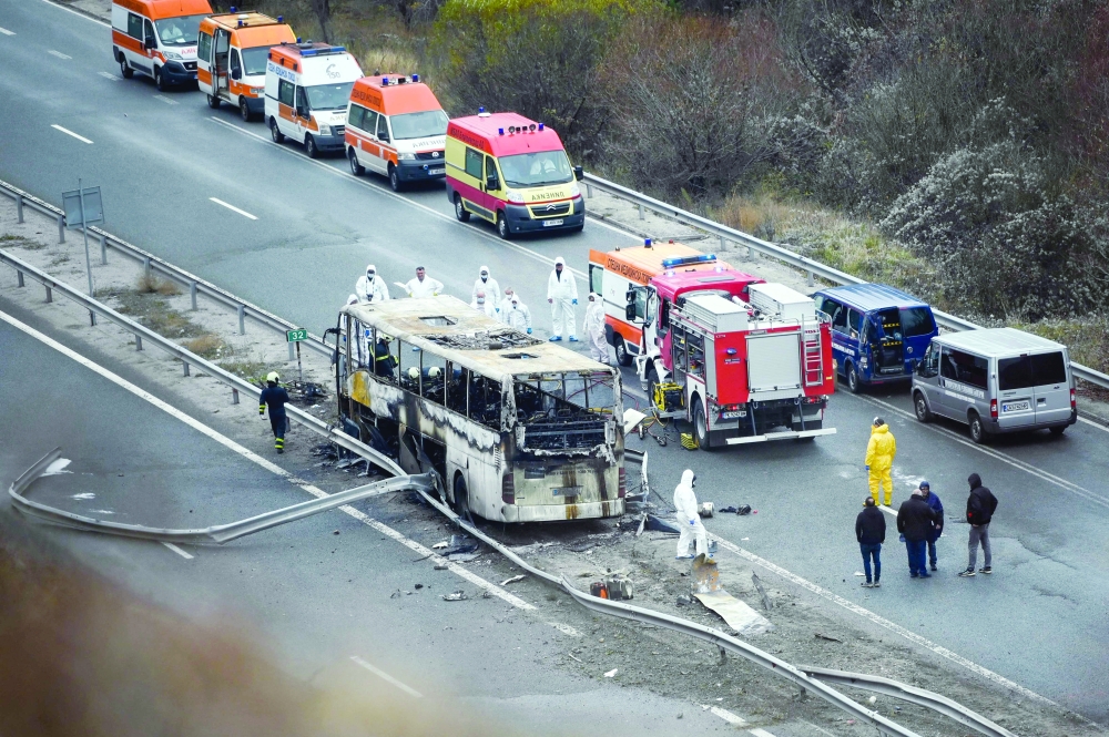 Officials work at the site of a bus accident, in which at least 46 people were killed, on a highway near the village of Bosnek, south of Sofia. - AFP