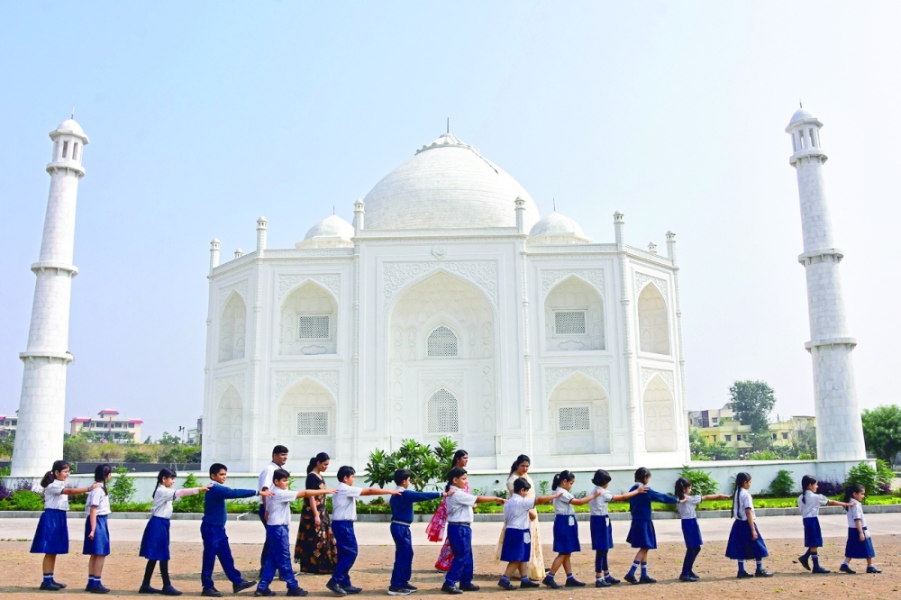 Schoolchildren walk past a replica of the Taj Mahal during their visit at Burhanpur in Madhya Pradesh. - AFP 