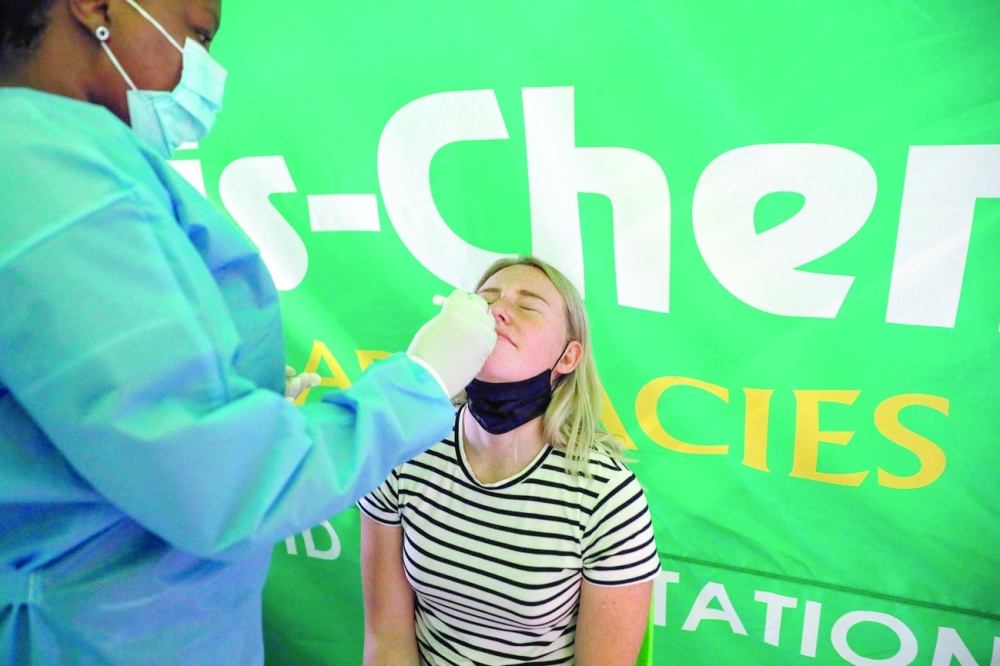 A healthcare worker conducts a polymerase chain reaction Covid-19 test  on a traveller at OR Tambo International Airport in Johannesburg after several countries banned flights from South Africa following the discovery of a new variant Omicron. - AFP