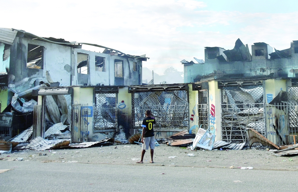 A man looks at damages in Honiara as a tense calm returned after days of intense rioting that left at least three dead and reduced swathes of the city to smouldering ruins.  - AFP
