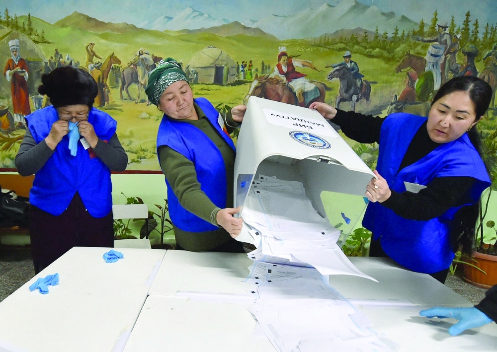 Members of a local election commission empty a ballot box to count votes as part of Kyrgyzstan's parliamentary election outside Bishkek. - AFP
