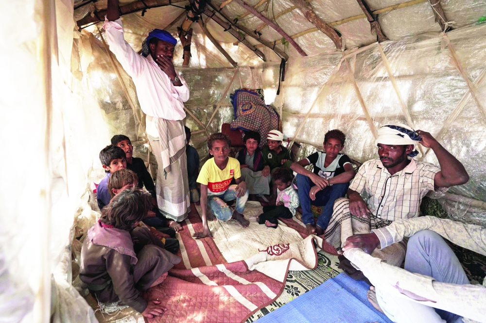 Yehya Hayba (R) and his children, who fled fighting between Ansar Allah fighters and the government forces, stay at the Al Sumya camp for internally displaced persons (IDP) east of Marib city. - AFP