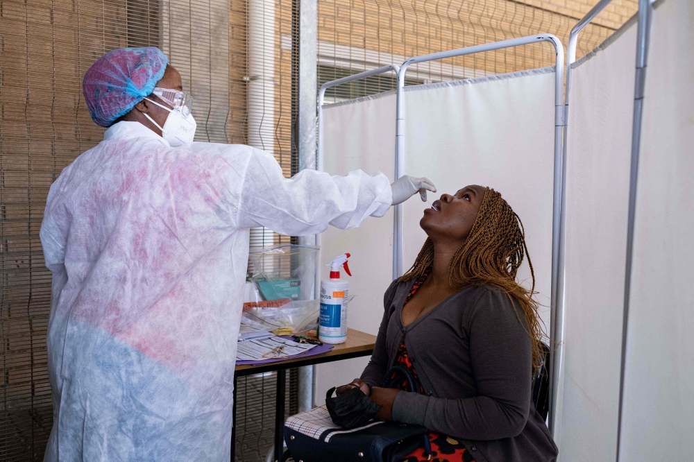 A healthcare worker conducts a PCR Covid-19 test at the Lancet laboratory in Johannesburg on November 30, 2021. 