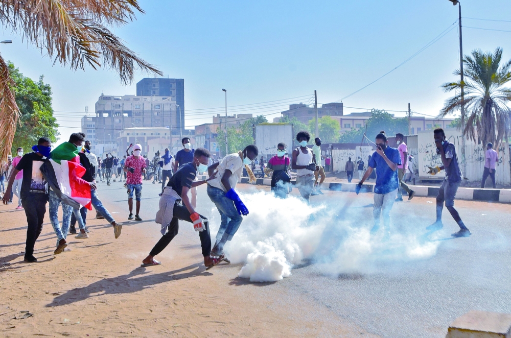 Demonstrators hurl tear gas canisters back at security forces amidst clashes in Khartoum following protests against a deal that saw the civilian prime minister reinstated after the military coup in October. - AFP

