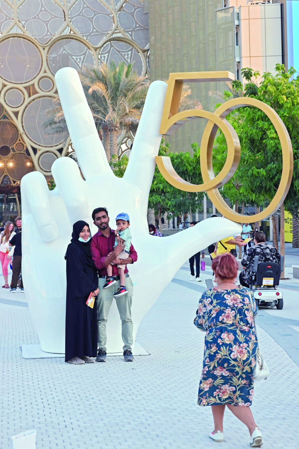 People pose next to a monument at Dubai Expo 2020 celebrating the UAE's 50th anniversary which falls on December 2. - AFP

