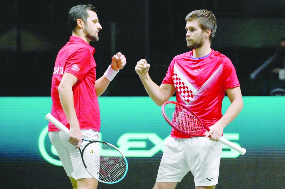 Croatia's Mate Pavic (L) and Croatia's Nikola Mektic celebrate winning a point against Serbia's Novak Djokovic and Serbia's Filip Krajinovic during the Davis Cup in Madrid. -- AFP
