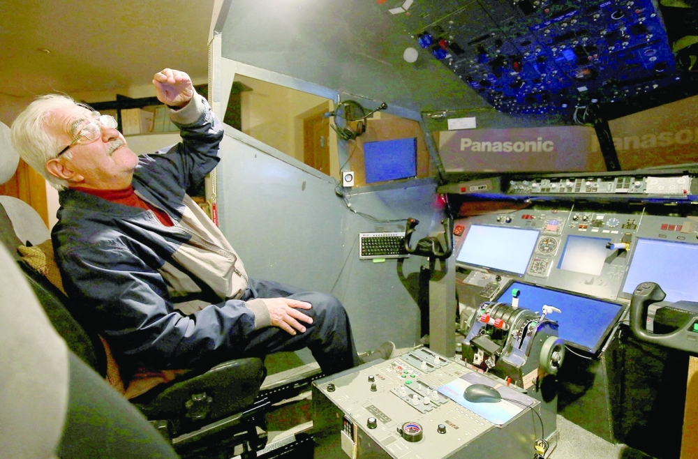 Muhammad Malhas sits at his flight simulator cockpit at his home in Jordan's capital Amman. - AFP