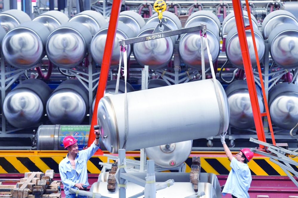 Employees work next to tanks for liquefied natural gas (LNG) at a factory in Xian, Shaanxi province, China. — Reuters 