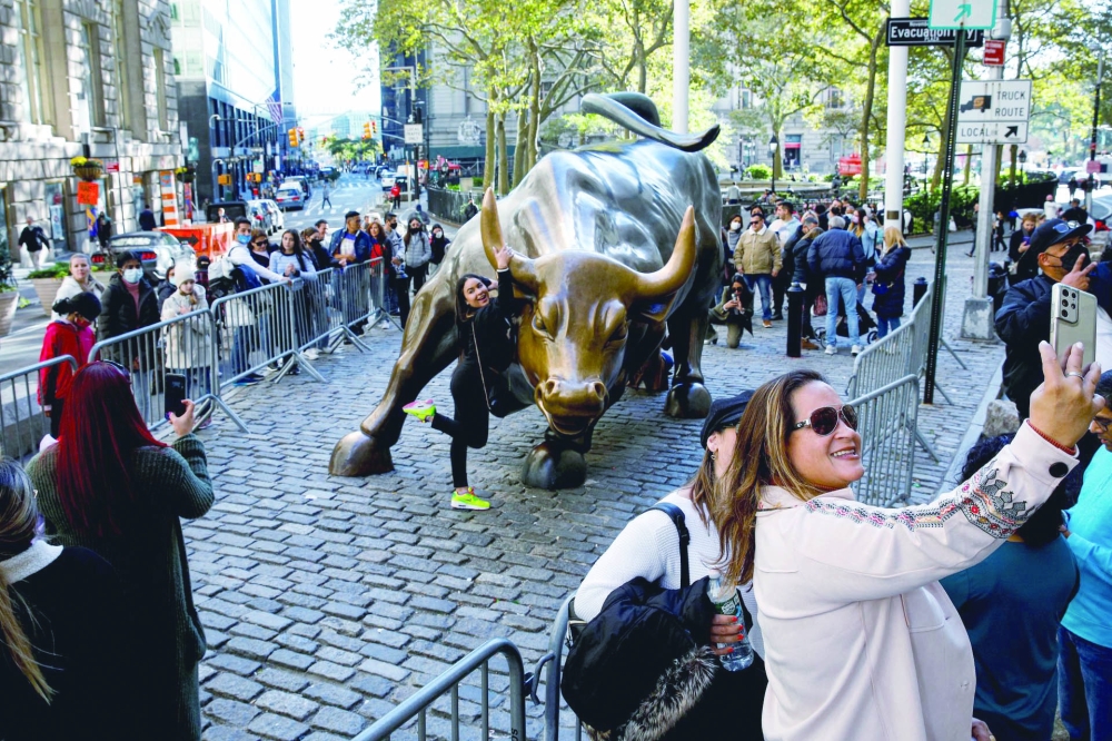 Tourists gather around the Charging Bull statue, also known as the Wall St Bull in New York. — Reuters