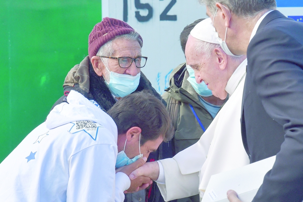 A man pays his respects to the Pope Francis during a meeting with refugees at the Reception and Identification Centre in Mytilene on the island of Lesbos. - AFP 
