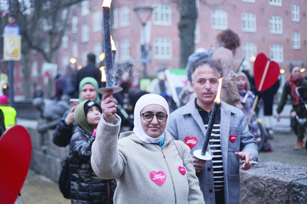 Syrian refugee Bilal Alkale (R) and his wife Sawsan Doungham take part in a protest against the deportation of Syrian families to their homeland in Copenhagen. - AFP 