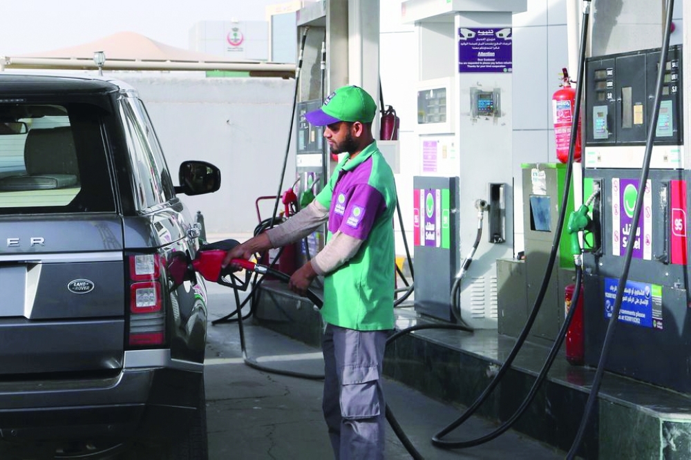 A worker fills a vehicle with petrol at a gas station in Riyadh, Saudi Arabia. — Reuters