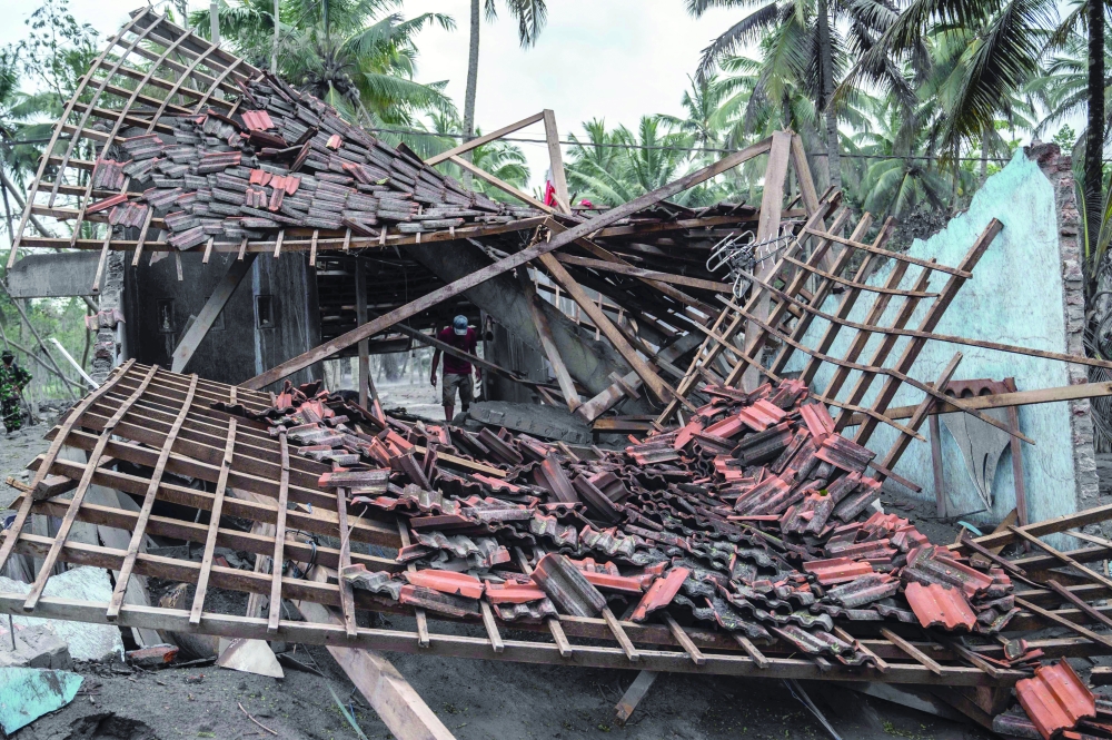 A man looks at a damaged home at Sumber Wuluh village in Lumajang following a volcanic eruption from Mount Semeru that killed a least fourteen people. - AFP


