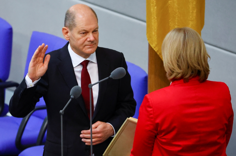 Newly elected German Chancellor Olaf Scholz is sworn-in by Parliament President Baerbel Bas during a session of the German lower house of parliament Bundestag, in Berlin, Germany, December 8, 2021. REUTERS/Fabrizio Bensch
