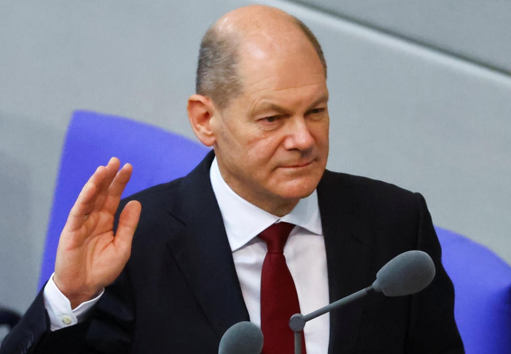 Newly elected German Chancellor Olaf Scholz is sworn-in by Parliament President Baerbel Bas during a session of the German lower house of parliament Bundestag, in Berlin, Germany, December 8, 2021. REUTERS/Fabrizio Bensch
