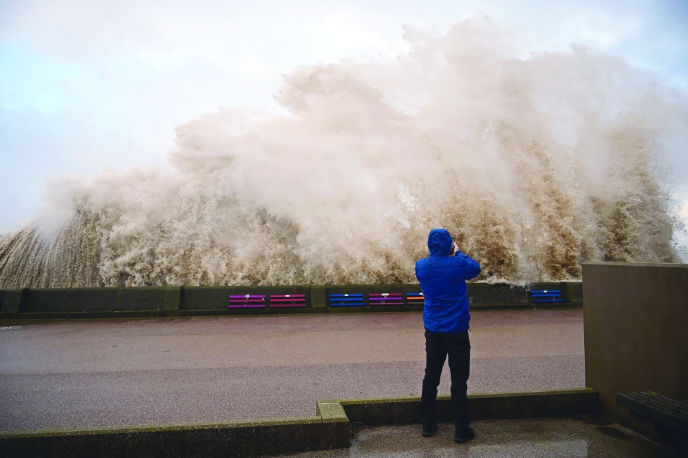 Waves crash over the promenade in New Brighton, north west England as Storm Barra swept over the country. - AFP

