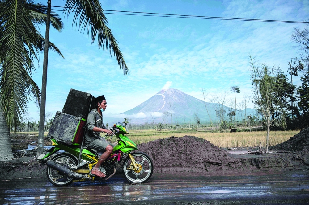 A villager evacuates her damaged home at Curah Kobokan village in Lumajang after Mount Semeru volcano eruption that killed at least 39 people. - AFP

