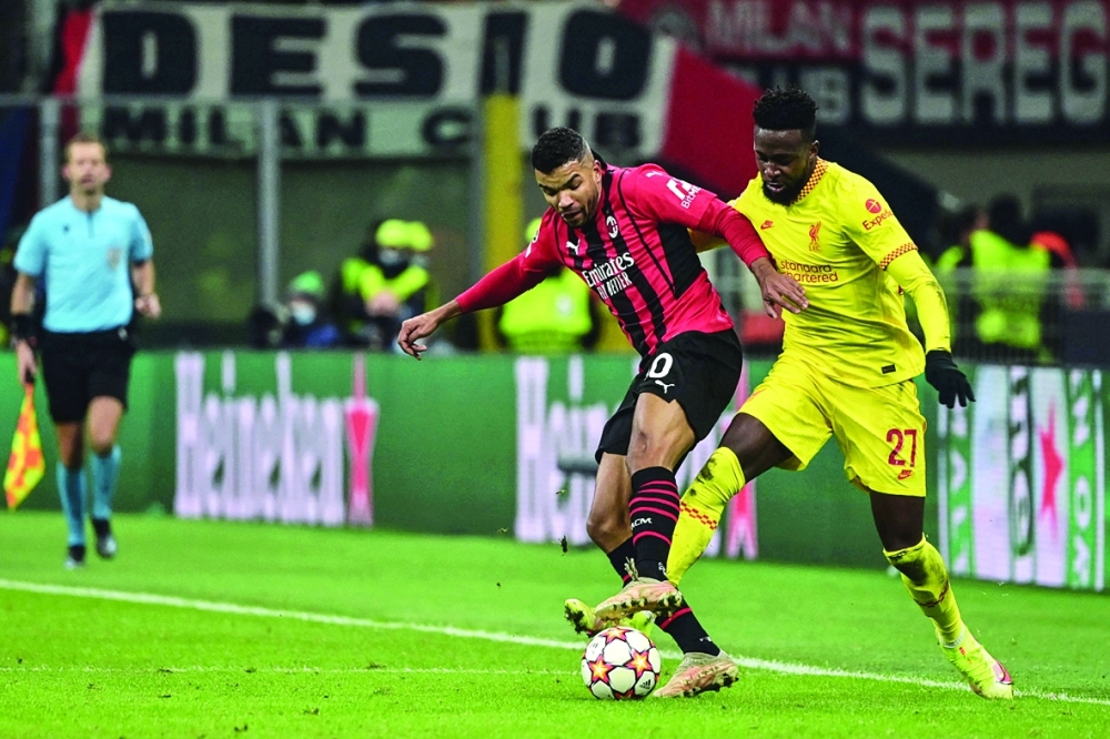 Liverpool's Belgian forward Divock Origi (R) tackles AC Milan's Brazilian midfielder Junior Messias during the UEFA Champions League Group B football match between AC Milan and Liverpool on December 7, 2021 at the San Siro stadium in Milan. (Photo by MIGUEL MEDINA / AFP)

