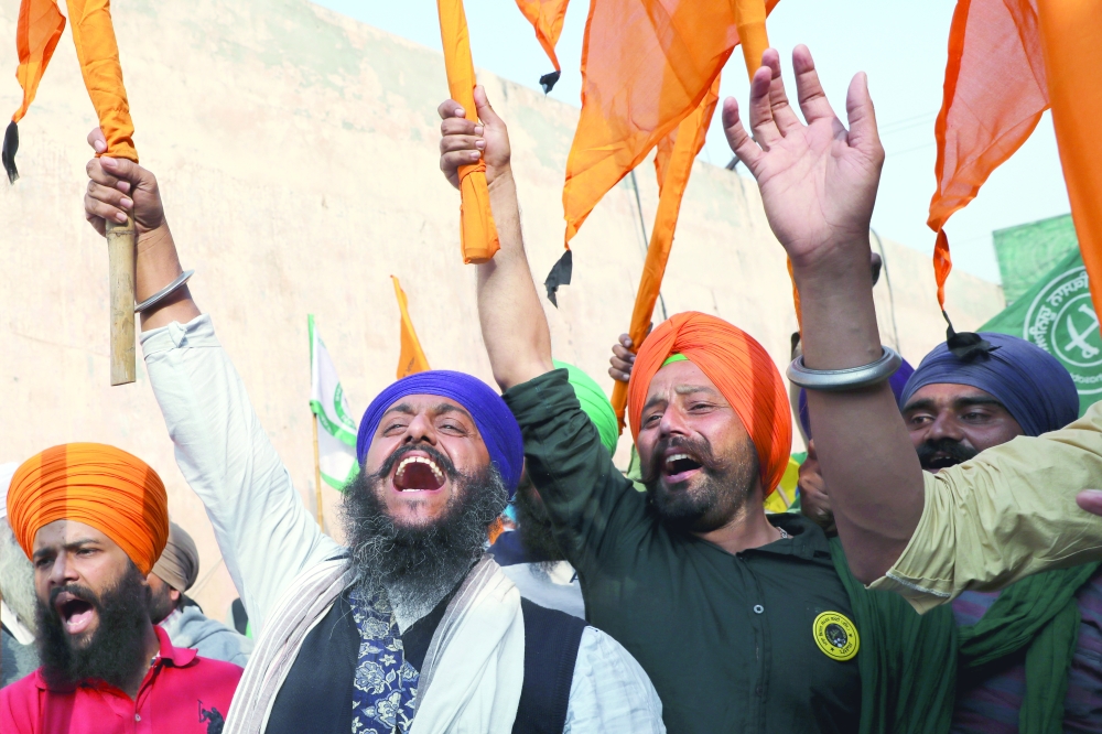 Farmers celebrate long-running protests being called off, after the government agreed to their demands, at the Singhu border protest site near the Delhi-Haryana border. - Reuters 