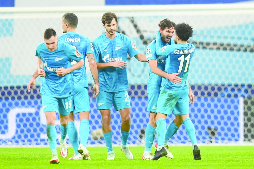 Zenit St. Petersburg's Magomed Ozdoev celebrates with team-mates after scoring their third goal during the UEFA Champions League group H match. -- AFP