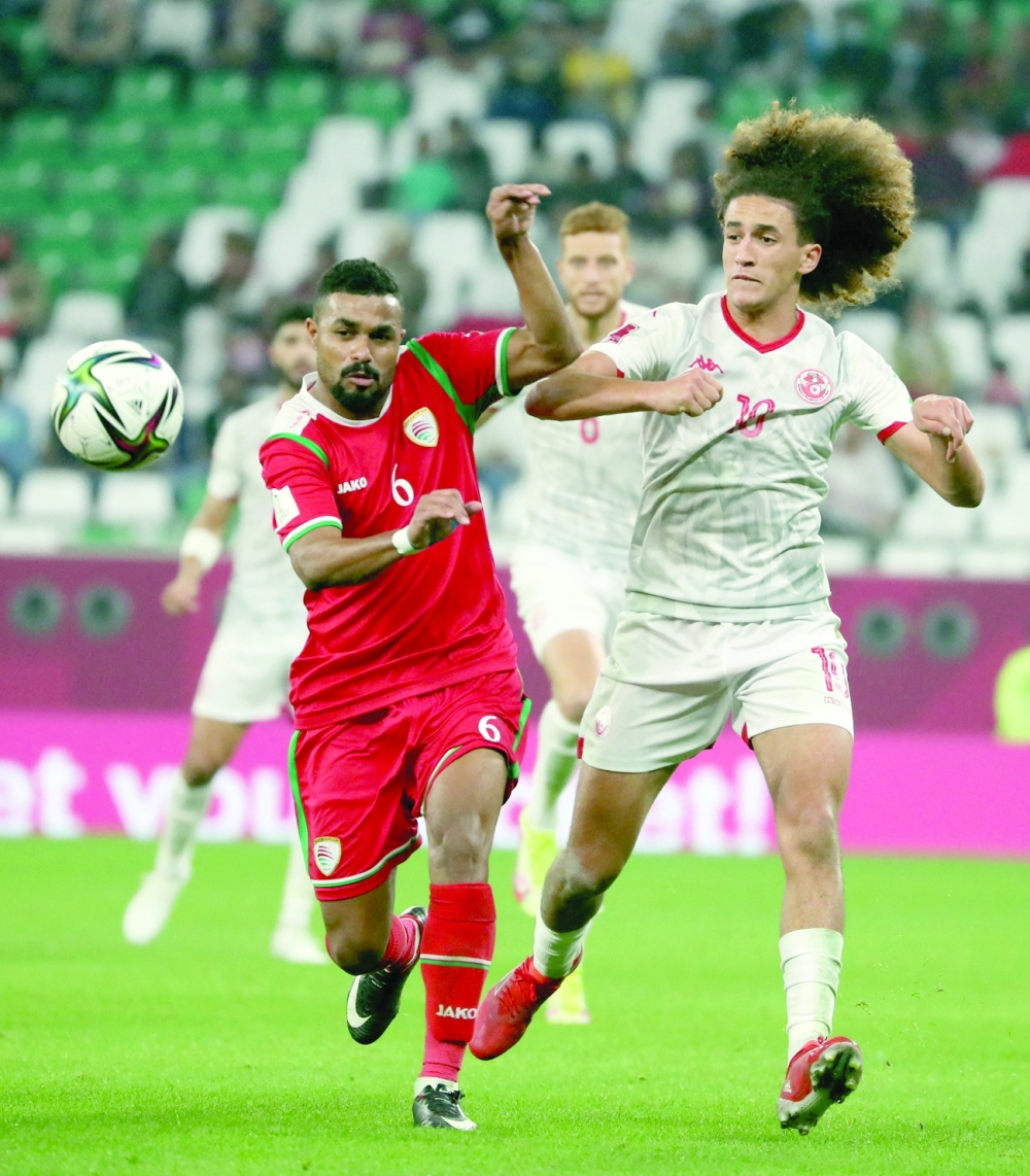 Oman's Ahmed Al Khamisi in action with Tunisia's Hannibal Mejbri. — Reuters 