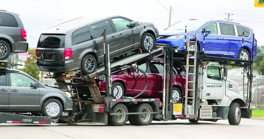 A car hauler transports newly assembled vehicles from the FCA Windsor Assembly plant in Windsor, Ontario, Canada. — Reuters