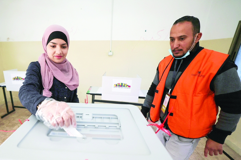 A woman casts her vote at a polling station during municipal elections in the village of Baitain, East of the occupied West Bank city of Ramallah, on Saturday. — AFP 