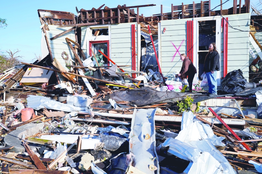 Janet Kimp, 66, and her son Michael Kimp, 25 stand outside their home after collecting belongings after a devastating outbreak of tornadoes ripped through several US states, in Mayfield, on Saturday. - Reuters