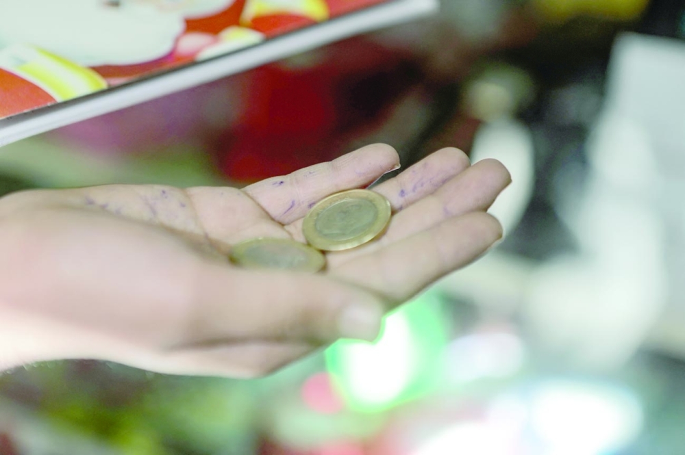 A Syrian boy shows Turkish coins while shopping in the city of Al-Bab. -- AFP