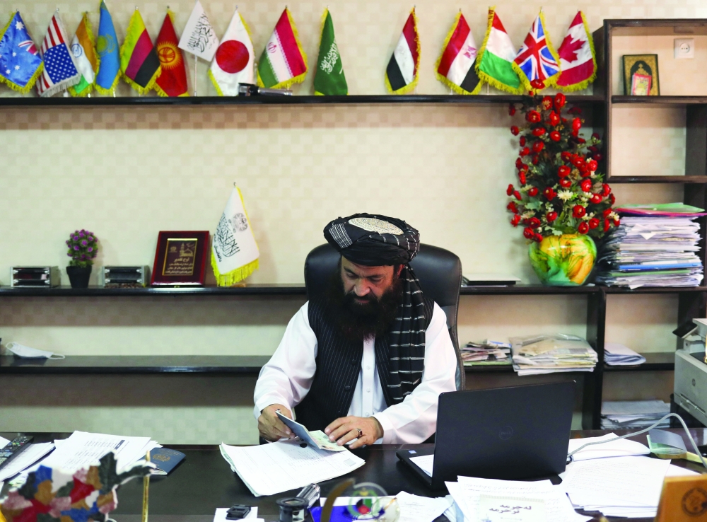 Alam Gul Haqqani, Head of Afghanistan Passport Office, checks documents at his office in Kabul. -- Reuters
