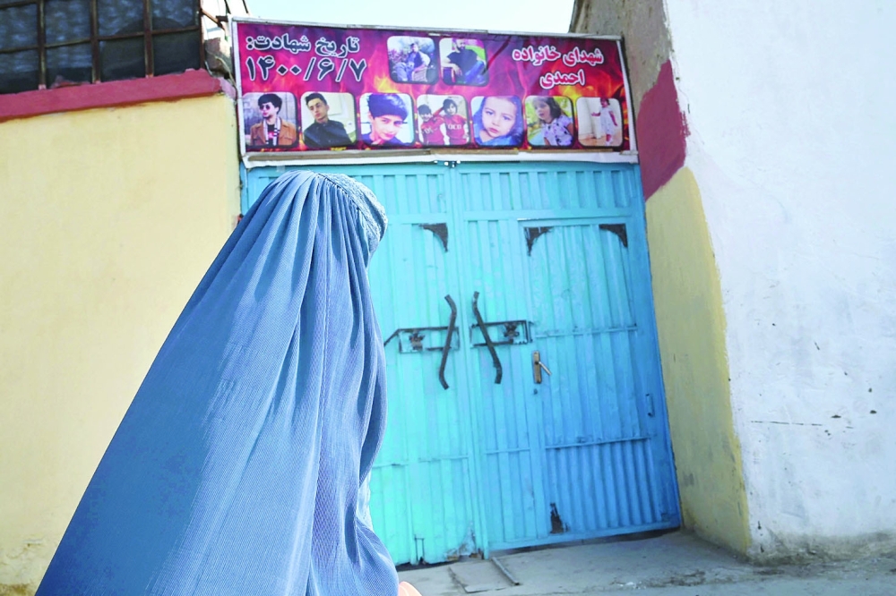 A woman walks past the house of Aimal Ahmadi, whose daughter Mailka and his elder brother Zimarai Ahmadi were among 10 relatives killed by a wrongly directed US drone strike on August 29, in Kabul on Tuesday. - AFP